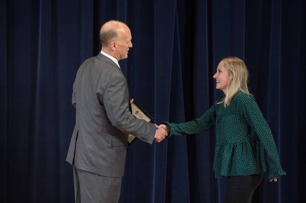 Graduate student shaking hands with Dean Potteiger on stage